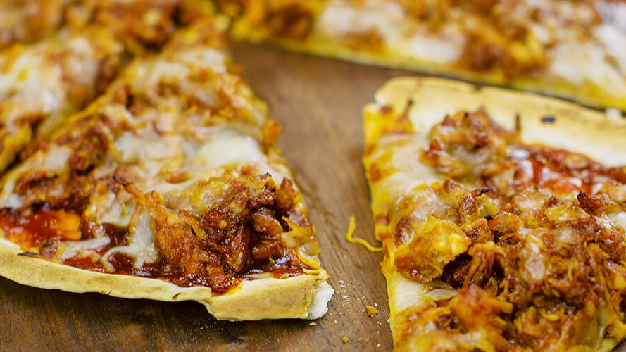 BBQ Chicken Tortilla Pizza sitting on wooden board