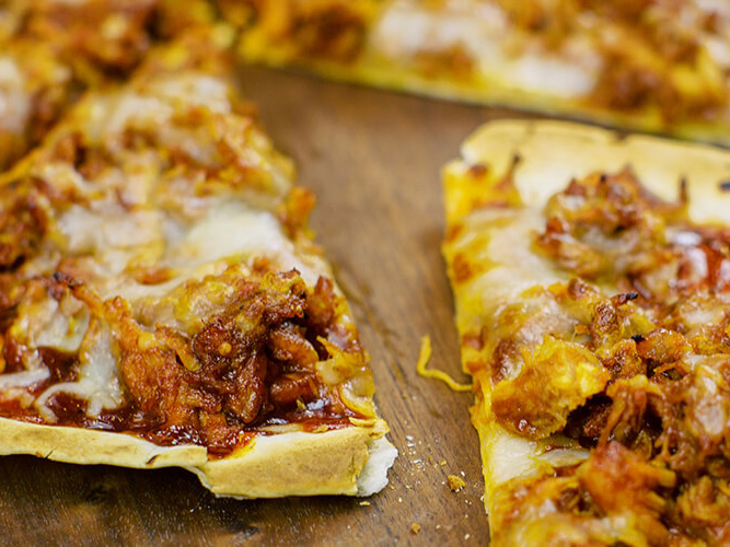 BBQ Chicken Tortilla Pizza sitting on wooden board