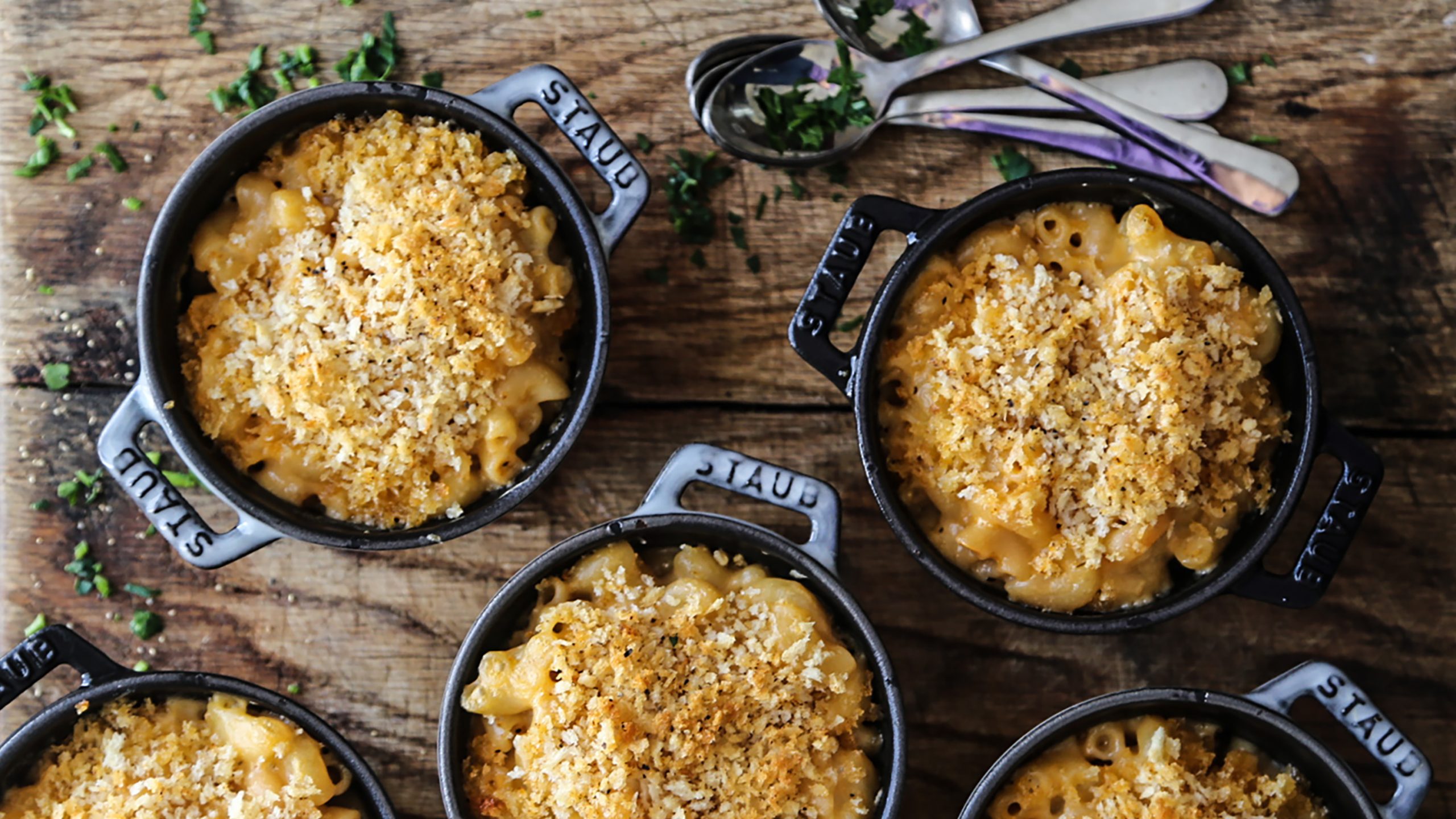 Individual black cast iron skillets holding Dorothy Lynch Mac & Cheese with a crispy top layer