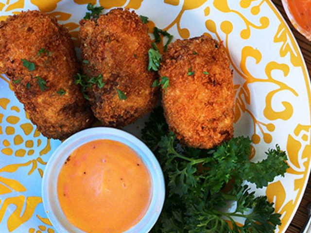 Three Breakfast Croquettes on a white and yellow patterned plate