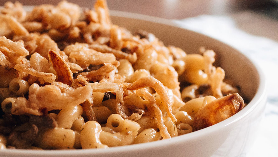 Cheeseburger Mac and cheese in a white bowl with crispy onions for garnish