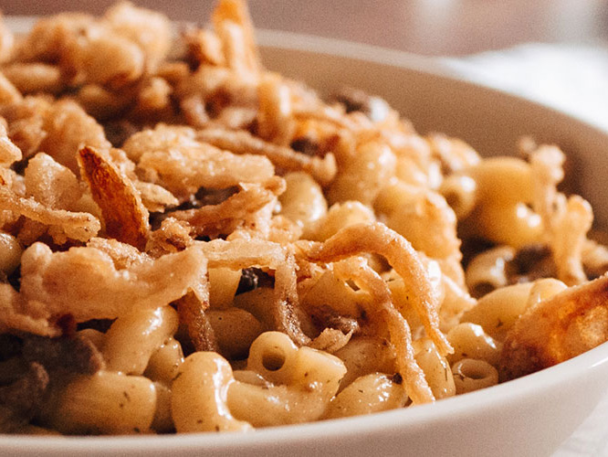 Cheeseburger Mac and cheese in a white bowl with crispy onions for garnish