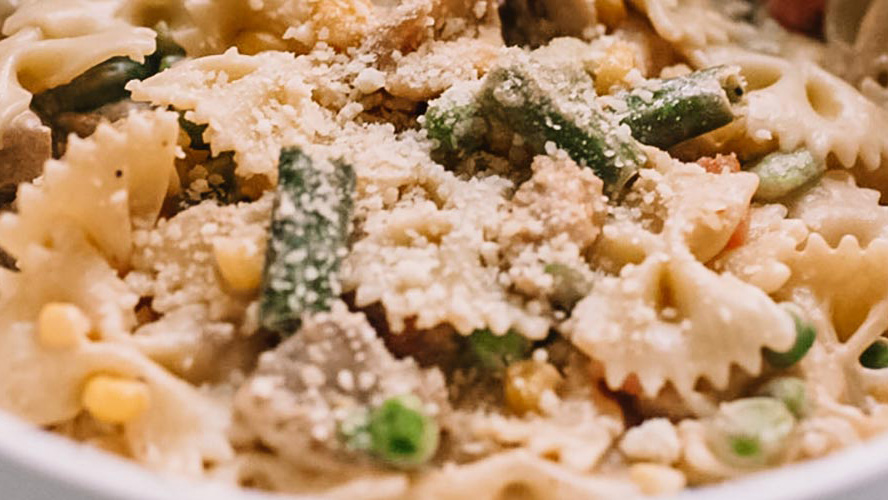 Creamy Dorothy Lynch Chicken & Vegetable Bowtie Pasta with Parmesan cheese on top