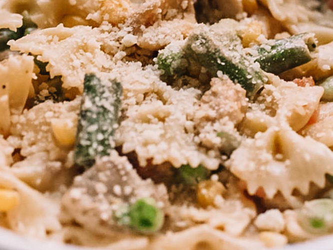 Creamy Dorothy Lynch Chicken & Vegetable Bowtie Pasta with Parmesan cheese on top