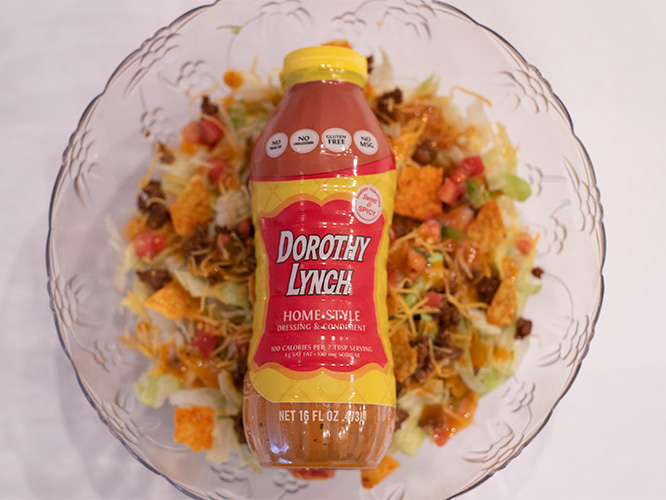 Dorothy Lynch Taco Salad in a clear bowl with a bottle of Dorothy Lynch laying on top inside the bowl