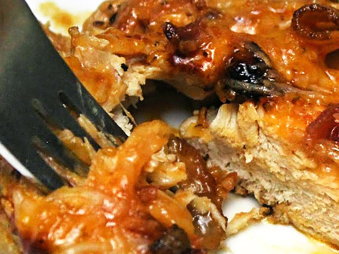 Tearing off a piece of Tasty Cheesy Chicken with Bacon with a fork