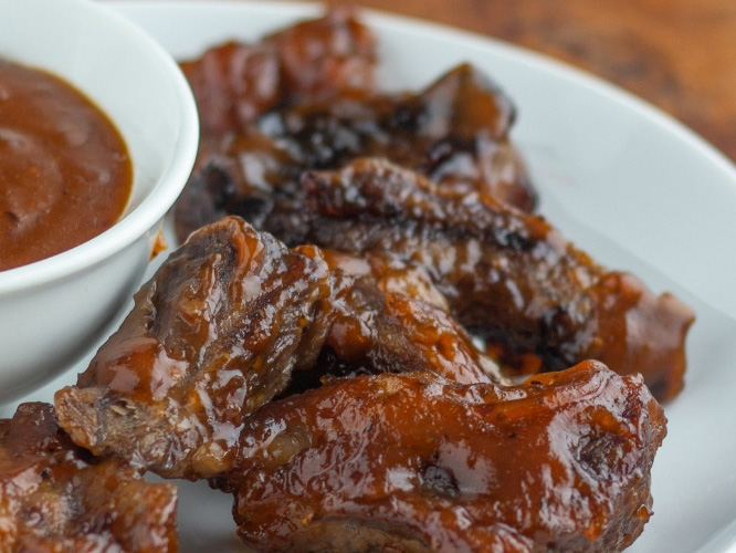 Sweet and Spicy Dorothy Lynch Glazed Short Ribs on a white plate with a bowl of Dorothy Lynch for dipping next to it