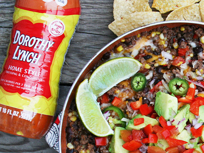 Mexican Ground Beef Skillet in a pan with tortilla chips, limes, and a Bottle of Dorothy Lynch in frame