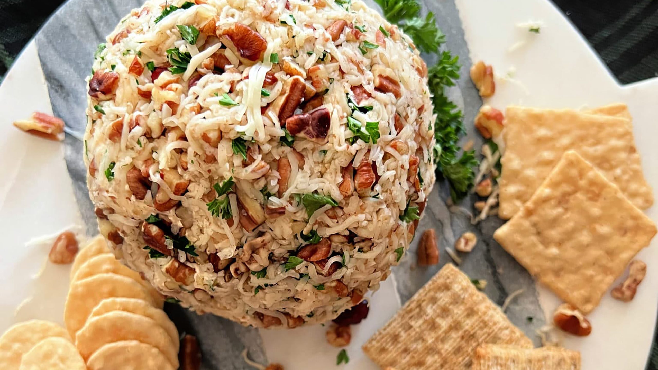 Dorothy Lynch Cheese Ball Appetizer Recipe on a marble serving plate with crackers surrounding