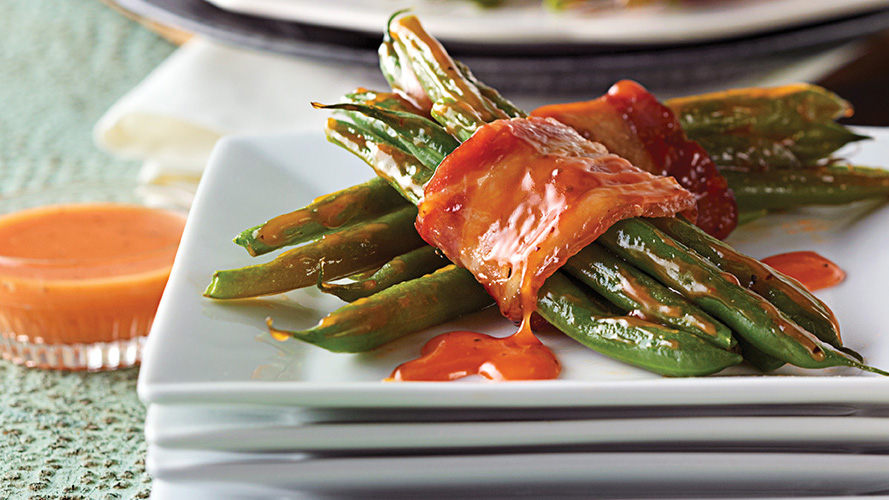 Dorothy Lynch Green Bean and Bacon Bundles Recipe on white plates stacked on top of each other