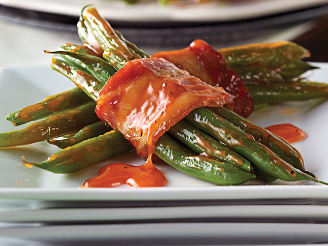 Dorothy Lynch Green Bean and Bacon Bundles Recipe on white plates stacked on top of each other