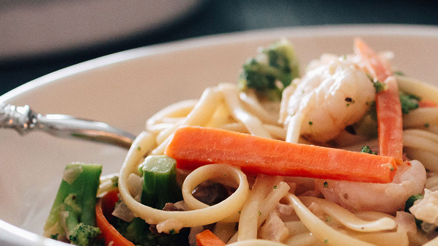 Close-up image of Creamy Linguine with Shrimp and Veggies with Dorothy Lynch Dressing Recipe in a white bowl