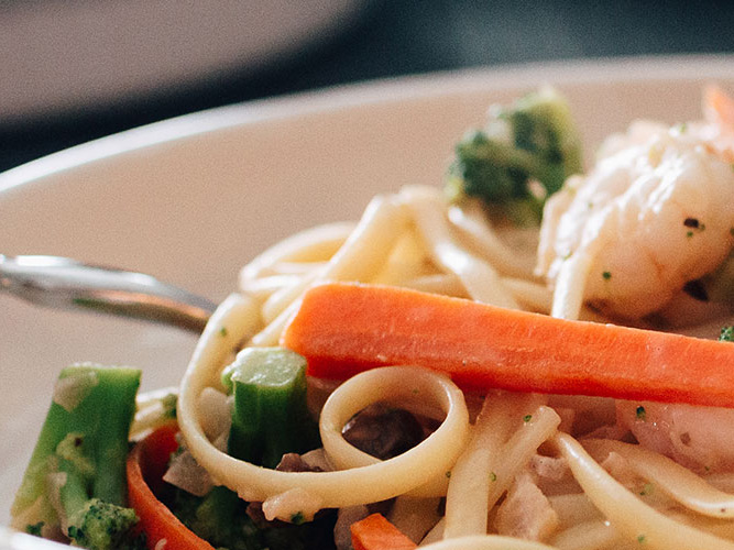 Close-up image of Creamy Linguine with Shrimp and Veggies with Dorothy Lynch Dressing Recipe in a white bowl