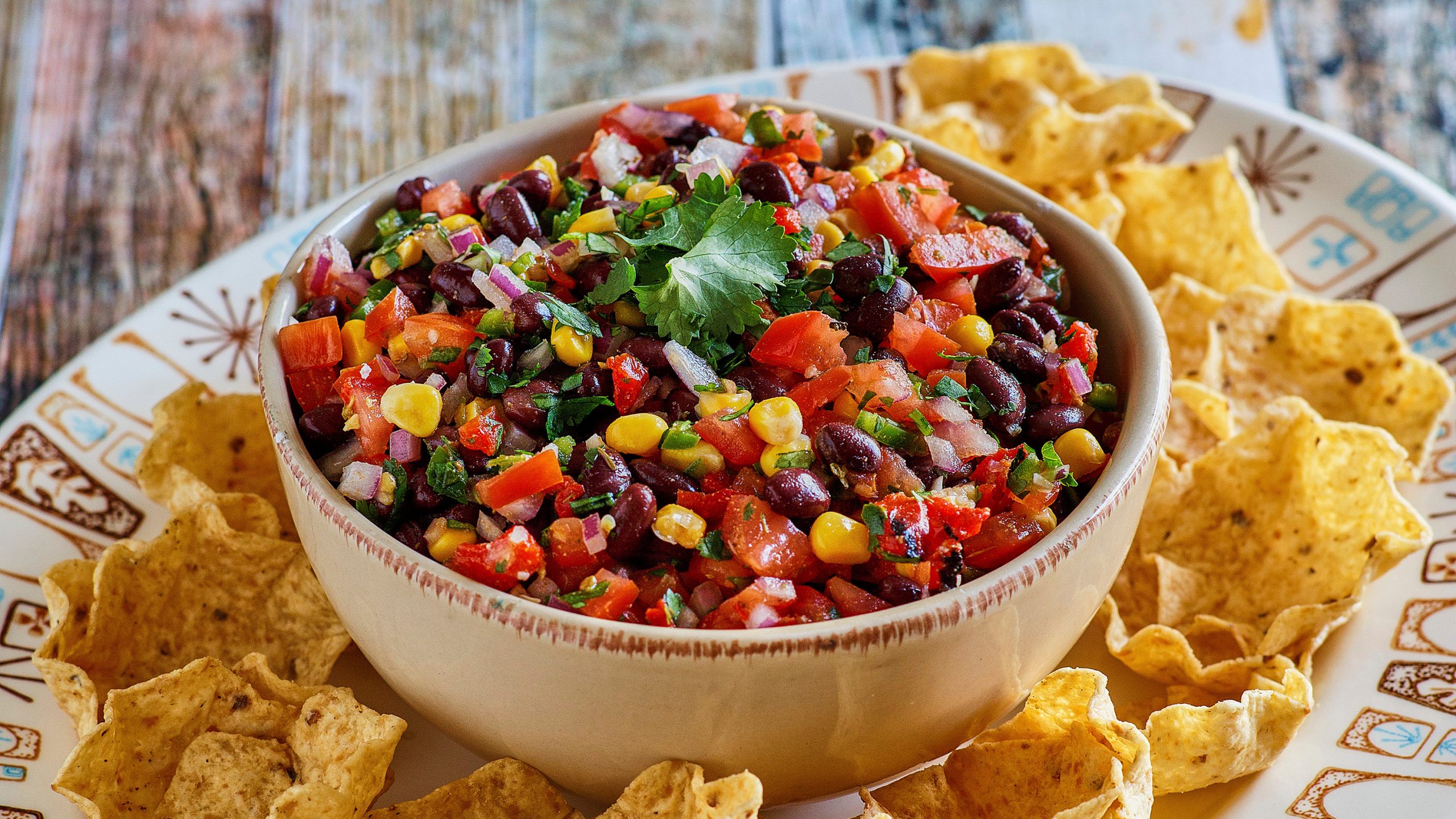 Dorothy’s Black Bean Salsa Recipe in a white bowl with tortilla chips surrounding