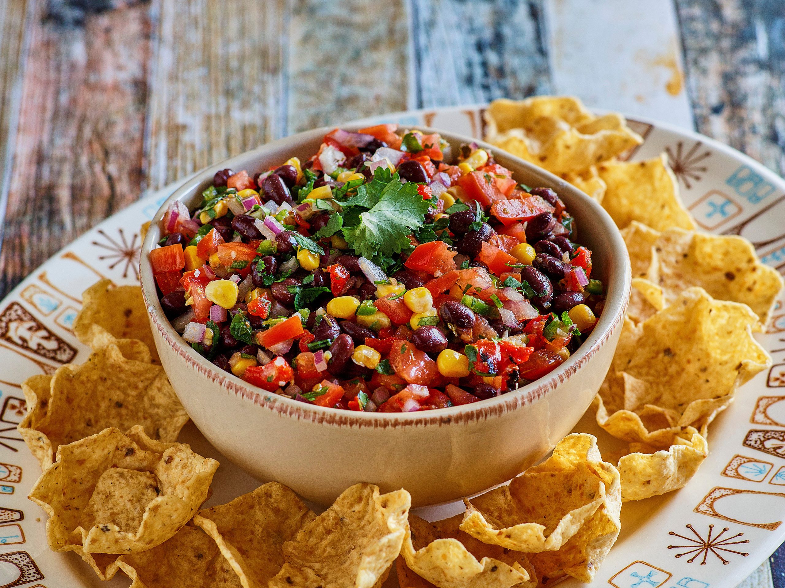 Dorothy’s Black Bean Salsa Recipe in a white bowl with tortilla chips surrounding