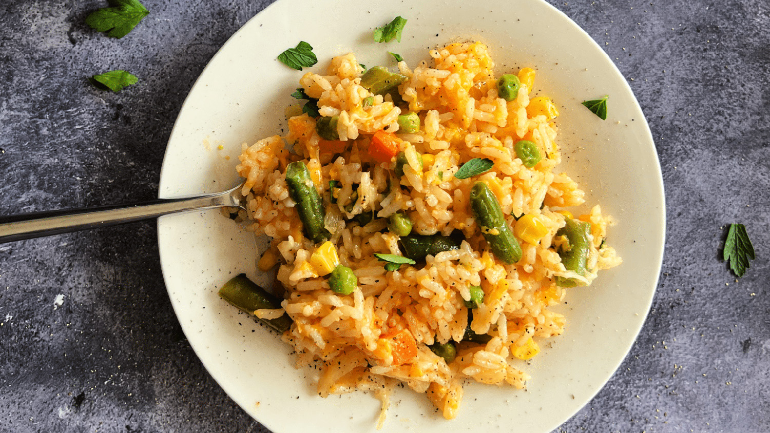 Dorothy Lynch Cheesy Vegetable Rice Bake Recipe on a white plate with a fork