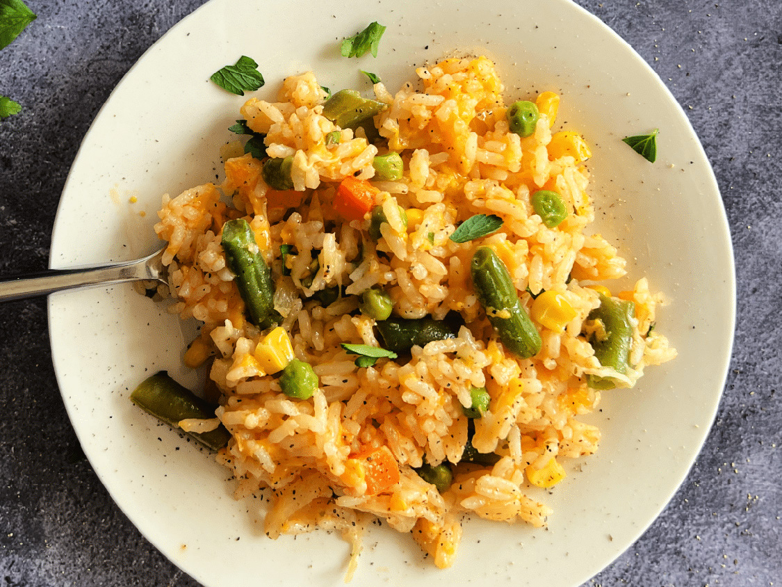 Dorothy Lynch Cheesy Vegetable Rice Bake Recipe on a white plate with a fork