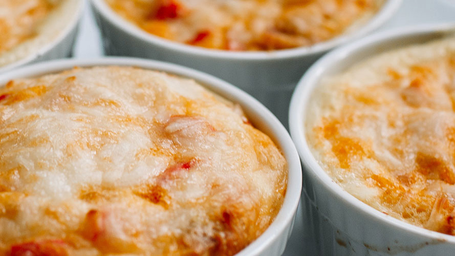 Individual white ramekins of Roasted Pepper and Ham Quiches with Dorothy Lynch Dressing Recipe