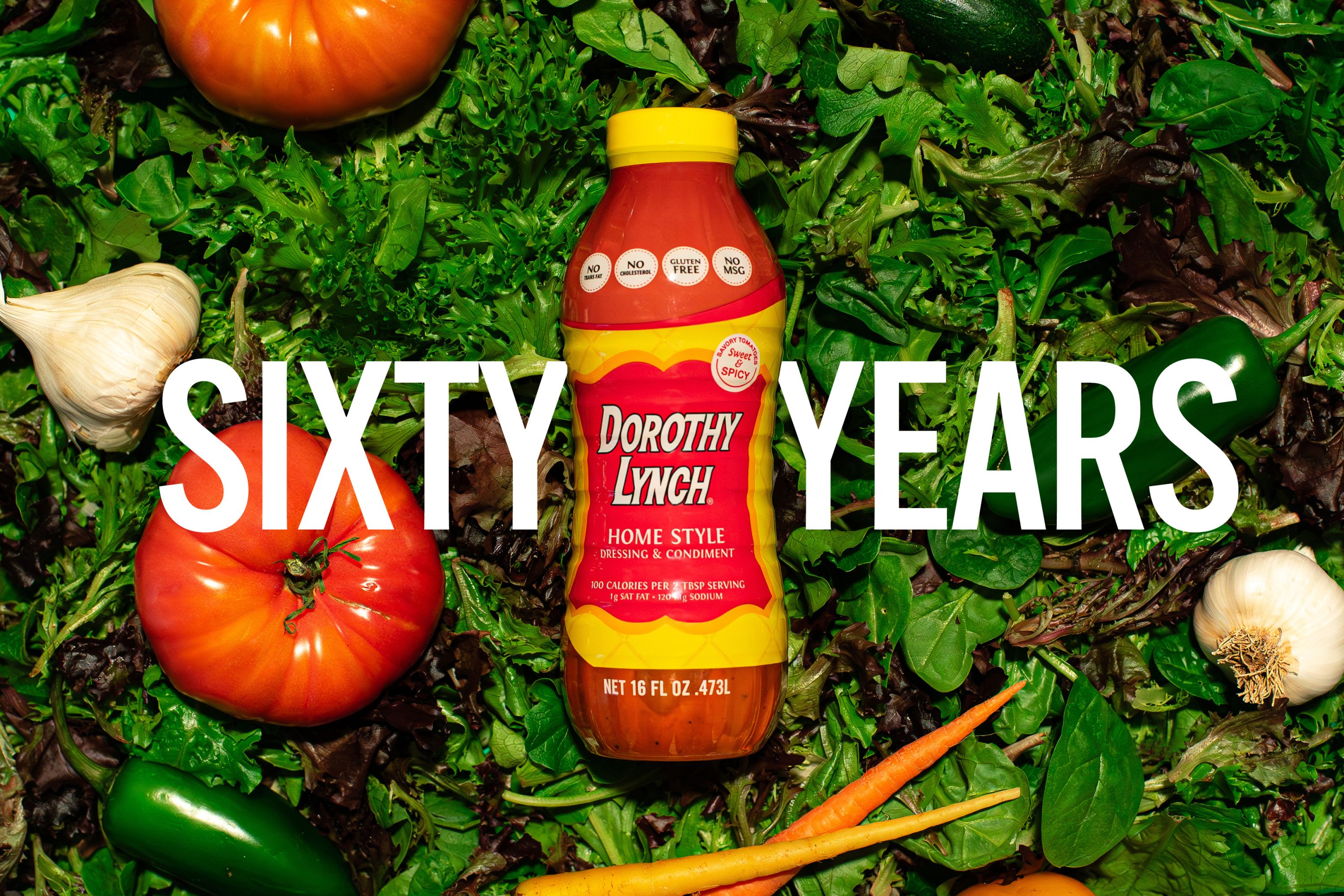 Dorothy Lynch Bottle laying in a pile of spinach and other greens with the words "SIXTY YEARS" written on top