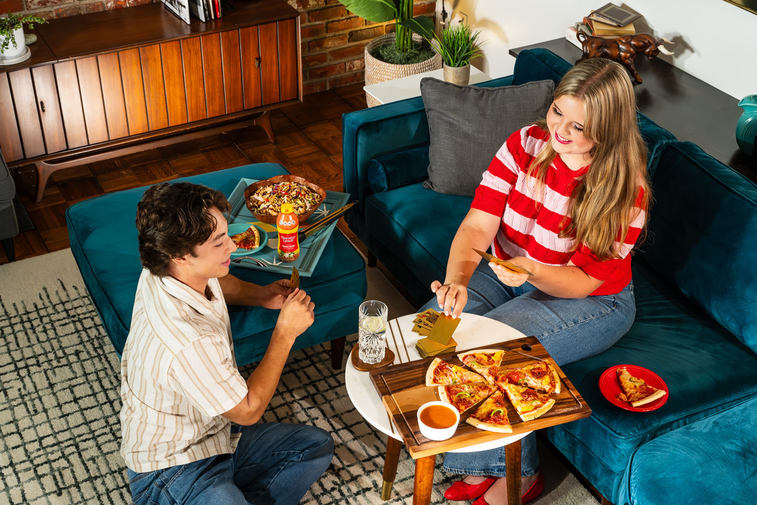 Midwestern couple with Dorothy Lynch Dressing pizza playing a card game